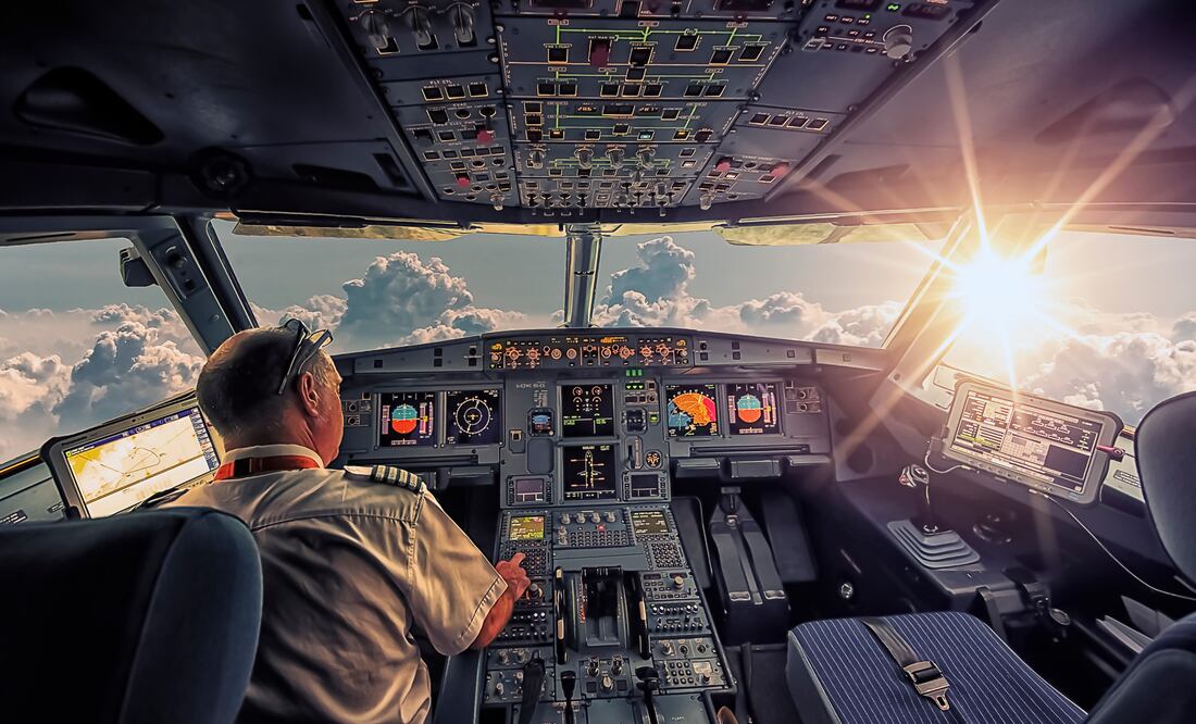 Piloto Trata de Apagar Motores en Cabina de Avión de Pasajeros. Foto iStock / StockByM