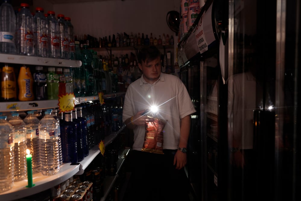Una persona utiliza su teléfono móvil como linterna en un ultramarinos en Valencia, este lunes, con motivo del apagón de suministro eléctrico. Foto: EFE/ Biel Alino