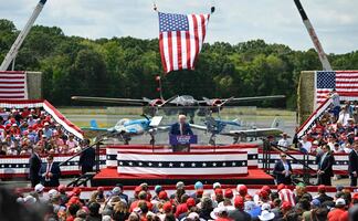 Trump aparece detrás de cristal antibalas en su primer evento al aire libre desde atentado