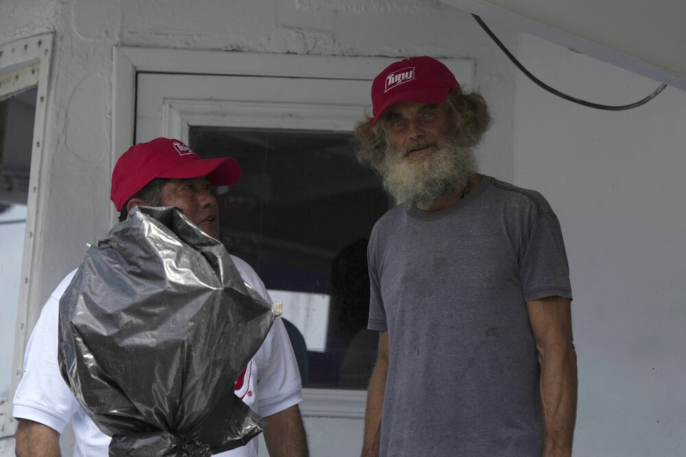Australian Timothy Lyndsay Shaddock, right, stands next to Mexican tuna boat Captain Oscar Meza Oregó as they arrive to port in Manzanillo, Mexico, Tuesday, Aug. 18, 2023. After being adrift with his dog for three months, Shaddock and his dog Bella were rescued by Meza's crew from his incapacitated catamaran Aloha Toa in the Pacific Ocean some 1,200 miles from land. (AP Photo/Fernando Llano)