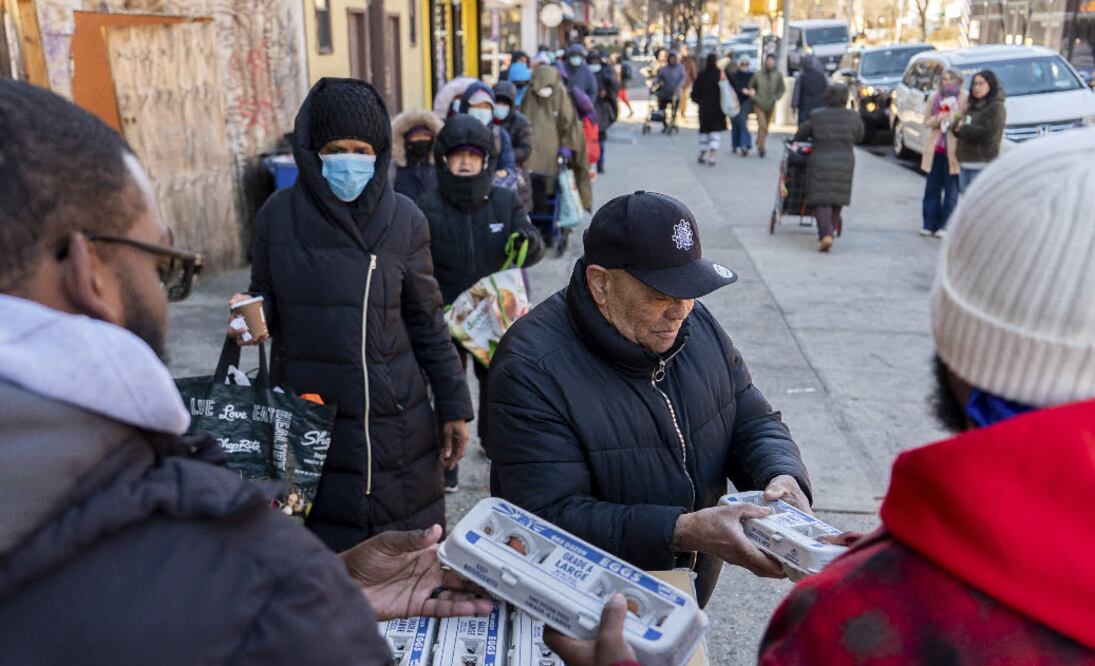 Abou Sow entrega cartones de huevo a personas que esperan formadas para recibirlos de manera gratuita de parte de FarmerJawn Agriculture el viernes 21 de marzo de 2025 en el barrio de Harlem, en Nueva York. (AP Foto/Julia Demaree Nikhinson)