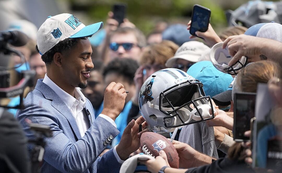 Bryce Young firma algunos autógrafos a aficionados de la NFL.  (AP Photo/Chris Carlson)