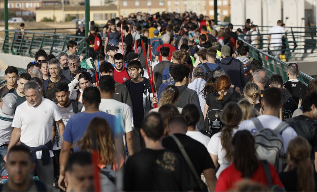Valencianos cruzan a pie para socorrer a las víctimas tras inundaciones por la DANA. EFE/ Biel Alino