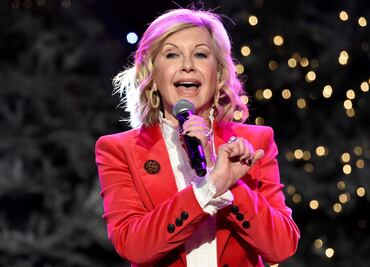 La reina Isabel II condecora a Olivia Newton John