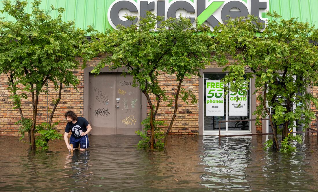 Un a persona usa un palo para tratar de desatascar un desagüe pluvial después de que una fuerte tormenta azotó Nueva Orleans el miércoles 10 de abril de 2024. (Chris Granger/The Times-Picayune/The New Orleans Advocate vía AP)