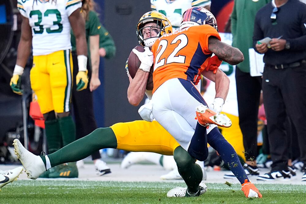 Luke Musgrave, atrás, ala cerrada de los Packers de Green Bay, es golpeado por el safety de los Broncos de Denver, Kareem Jackson (22), durante la segunda mitad del partido de la NFL, en Denver, el domingo 22 de octubre de 2023. Jackson fue castigado y expulsado del partido después de la jugada. (AP Foto/Jack Dempsey)