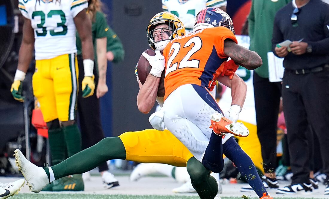 Luke Musgrave, atrás, ala cerrada de los Packers de Green Bay, es golpeado por el safety de los Broncos de Denver, Kareem Jackson (22), durante la segunda mitad del partido de la NFL, en Denver, el domingo 22 de octubre de 2023. Jackson fue castigado y expulsado del partido después de la jugada. (AP Foto/Jack Dempsey)